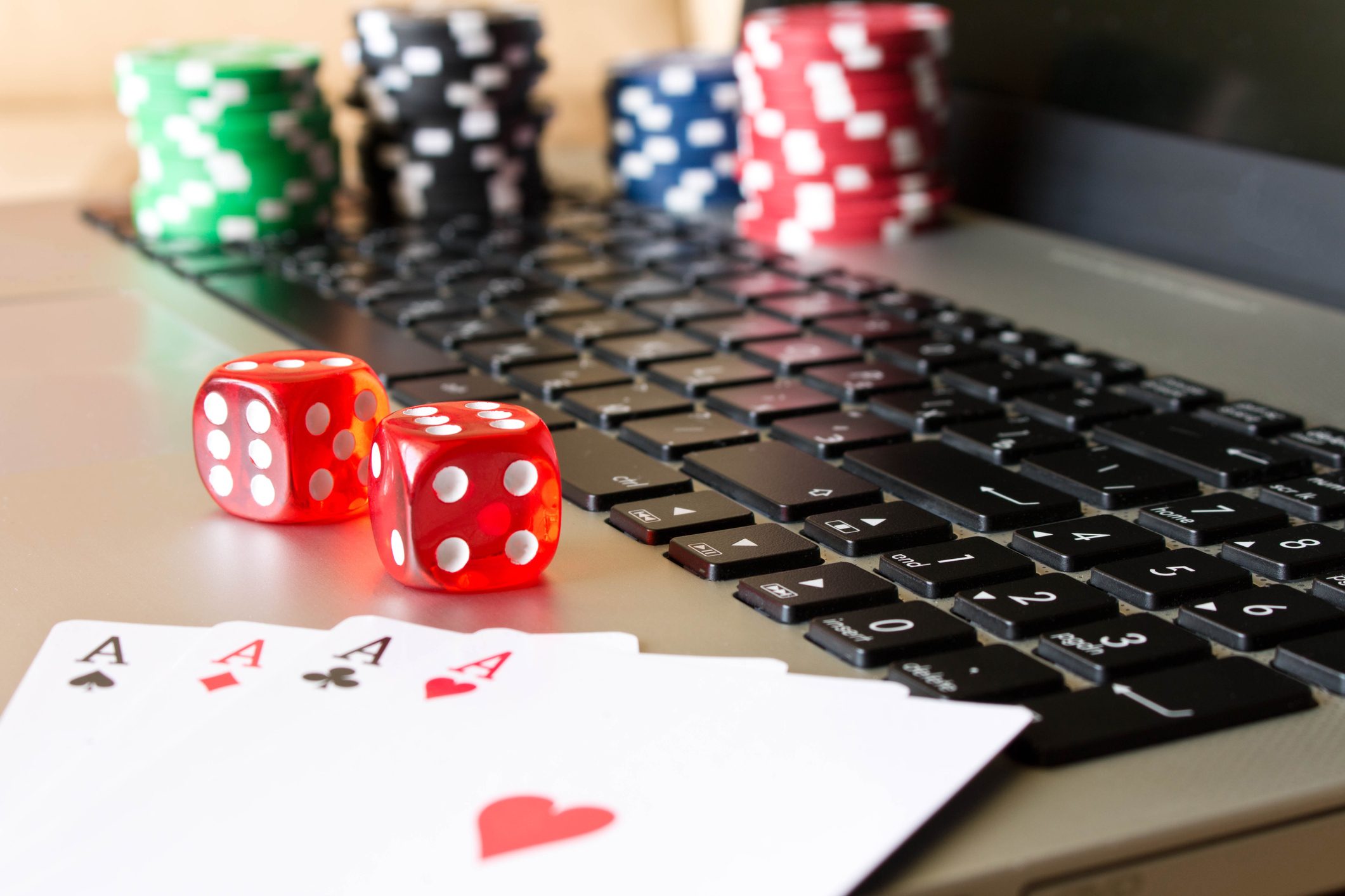 dice-poker-chips-and-playing-cards-on-laptop-the-concept-of-online-games
